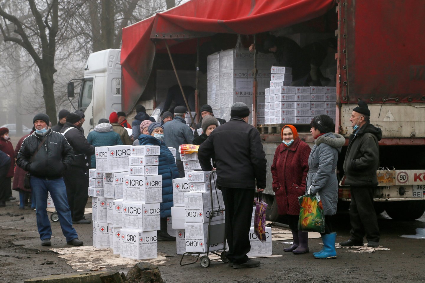 Tarptautinio Raudonojo Kryžiaus komiteto humanitarinės pagalbos dalijimo metu separatistų kontroliuojamame Donecko mieste, Ukrainoje, vietos gyventojai renkasi prie krovininės priekabos, prikrautos dėžių su maisto produktais ir asmens higienos priemonėmis.<br>Reuters/Scanpix nuotr.
