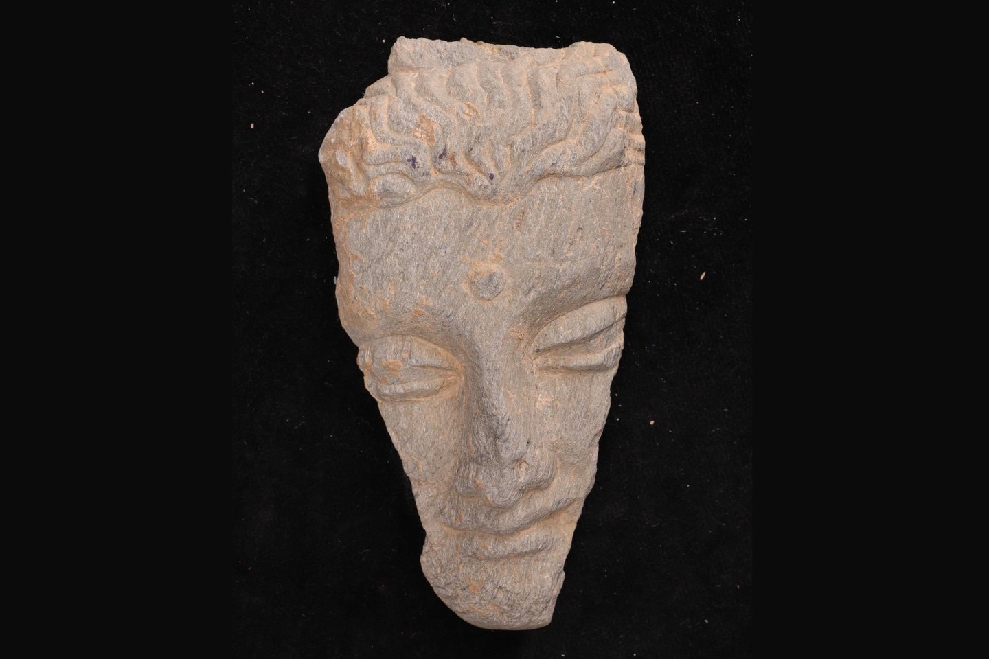  Per kasinėjimus Barikote rasta tūkstančiai senovinių artefaktų, tarp jų ir šis skalūne iškaltas Budos veidas.<br> ISMEO / Ca' Foscari Universiteto nuotr.