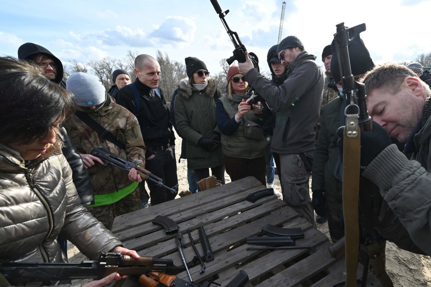  Savaitės pradžioje, dar prieš būsimą Rusijos invaziją ukrainiečiai pirko ginklus, šaudmenis ir net snaiperinius šautuvus, o trečiadienį prie ginklų parduotuvių driekėsi ilgos eilės.<br> AFP / Scanpix nuotr.