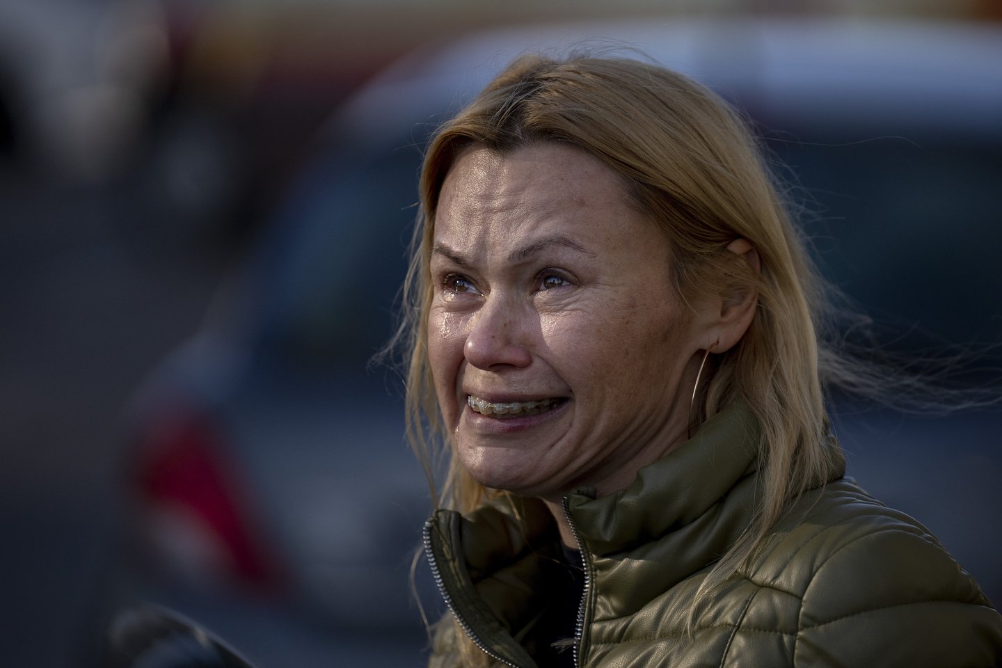 Moteris žiūri į savo namus, į kuriuos pataikė raketa. Kijevas.<br>AP/Scanpix nuotr.