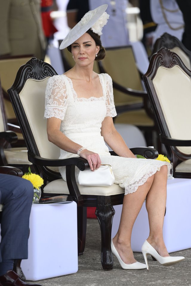  Catherine ir princas Williamas dalyvavo inauguraciniame Jamaikos gynybos pajėgų parade. Kunigaikštienės pasirinkimas – „Alexander McQueen“ nėriniais puošta balta suknelė, „Emmy London“ aukštakulniai, „Anya Hindmarch“ rankinė ir Philipo Treacy skrybėlė. „Kunigaikštienė iš savo lagamino išsitraukė dar vieną savo mylimos dizainerės, kūrusios jai vestuvinę suknelę, derinį. Šios suknelės nėriniai išties primena vestuvinę suknelę“, – komentavo stilistė.<br> Scanpix nuotr.