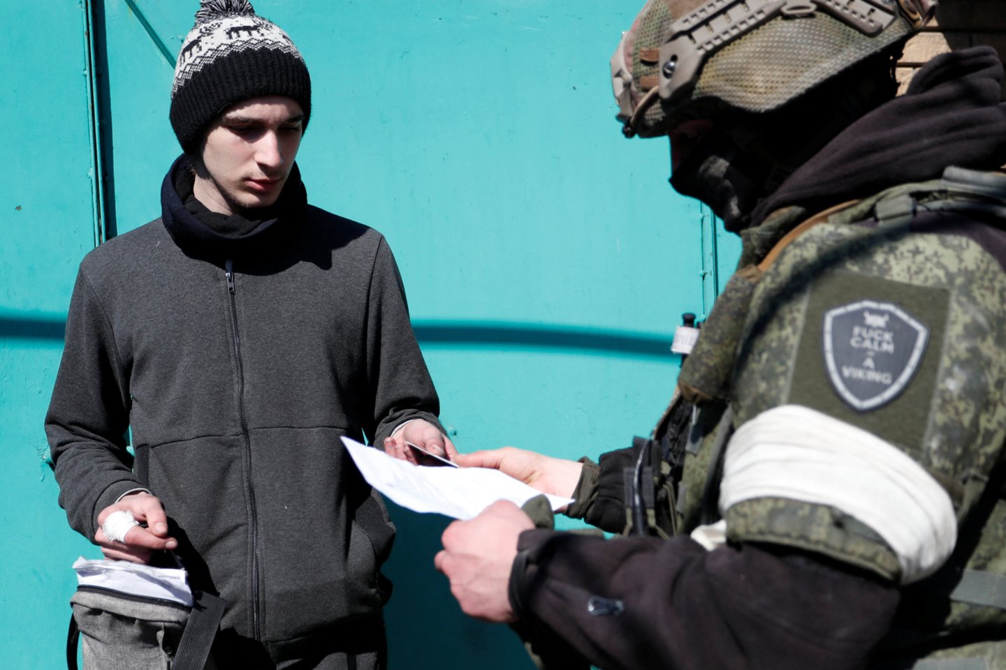  Prorusiškų pajėgų karys Mariupolyje tikrina dokumentus.<br> Reuters/Scanpix nuotr.