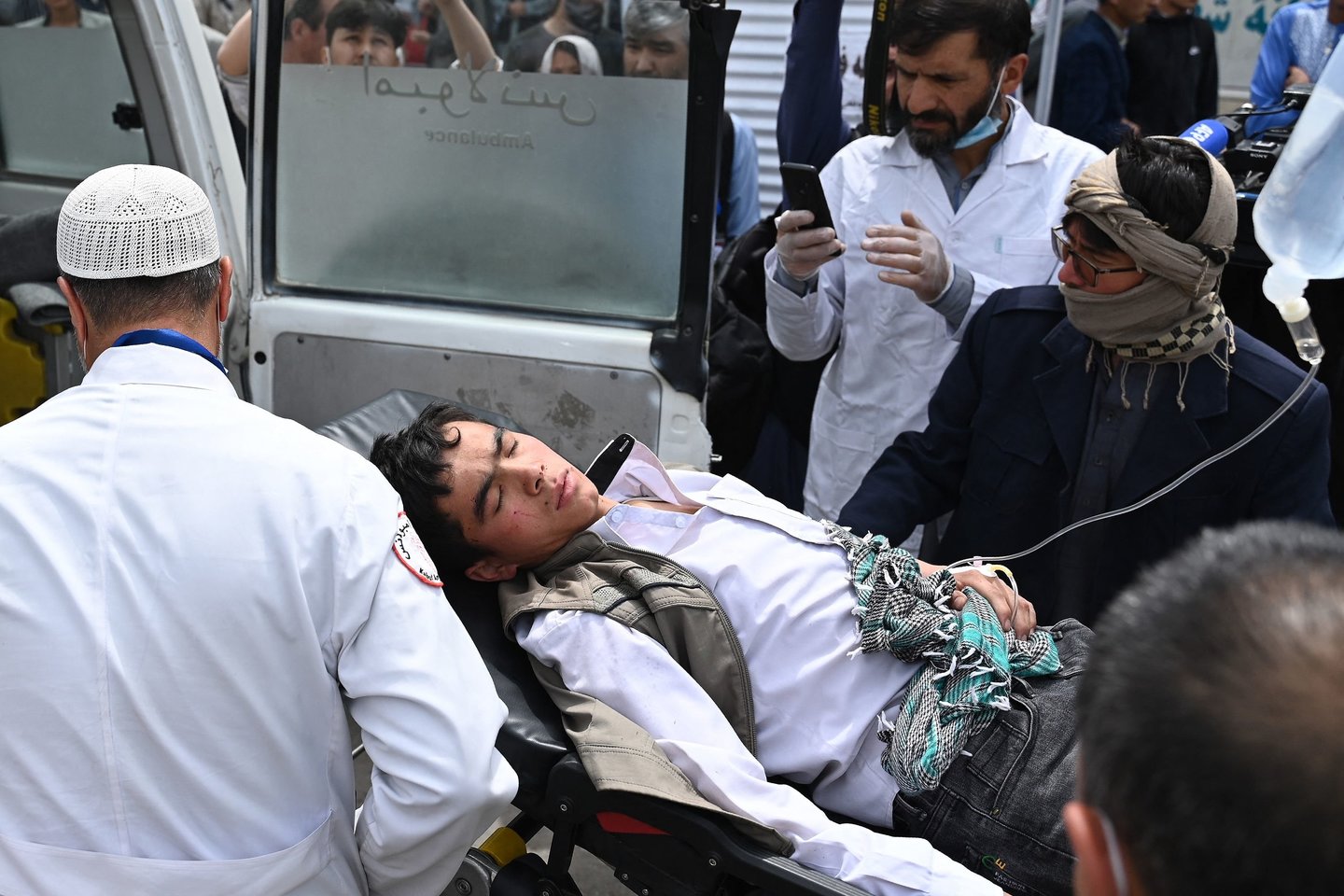 Po trijų sprogimų, nugriaudėjusių berniukų mokykloje šiitų hazarų kvartale, medicinos personalas prie ligoninės ant neštuvų neša sužeistą jaunuolį.<br>AFP/Scanpix nuotr.