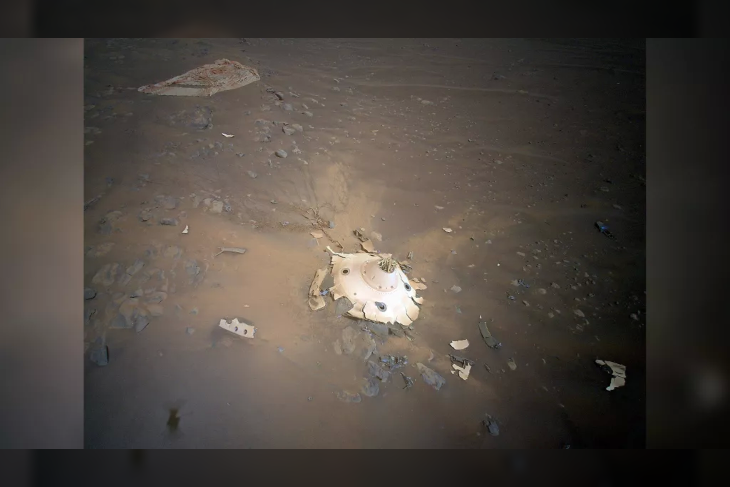  Nuotraukoje matyti aparatas, apsaugojęs sraigtasparnį ir marsaieigį „Perseverance“, kai 2021 m. vasario 18 d. jie nusileido ant Marso paviršiaus.<br> NASA nuotr.