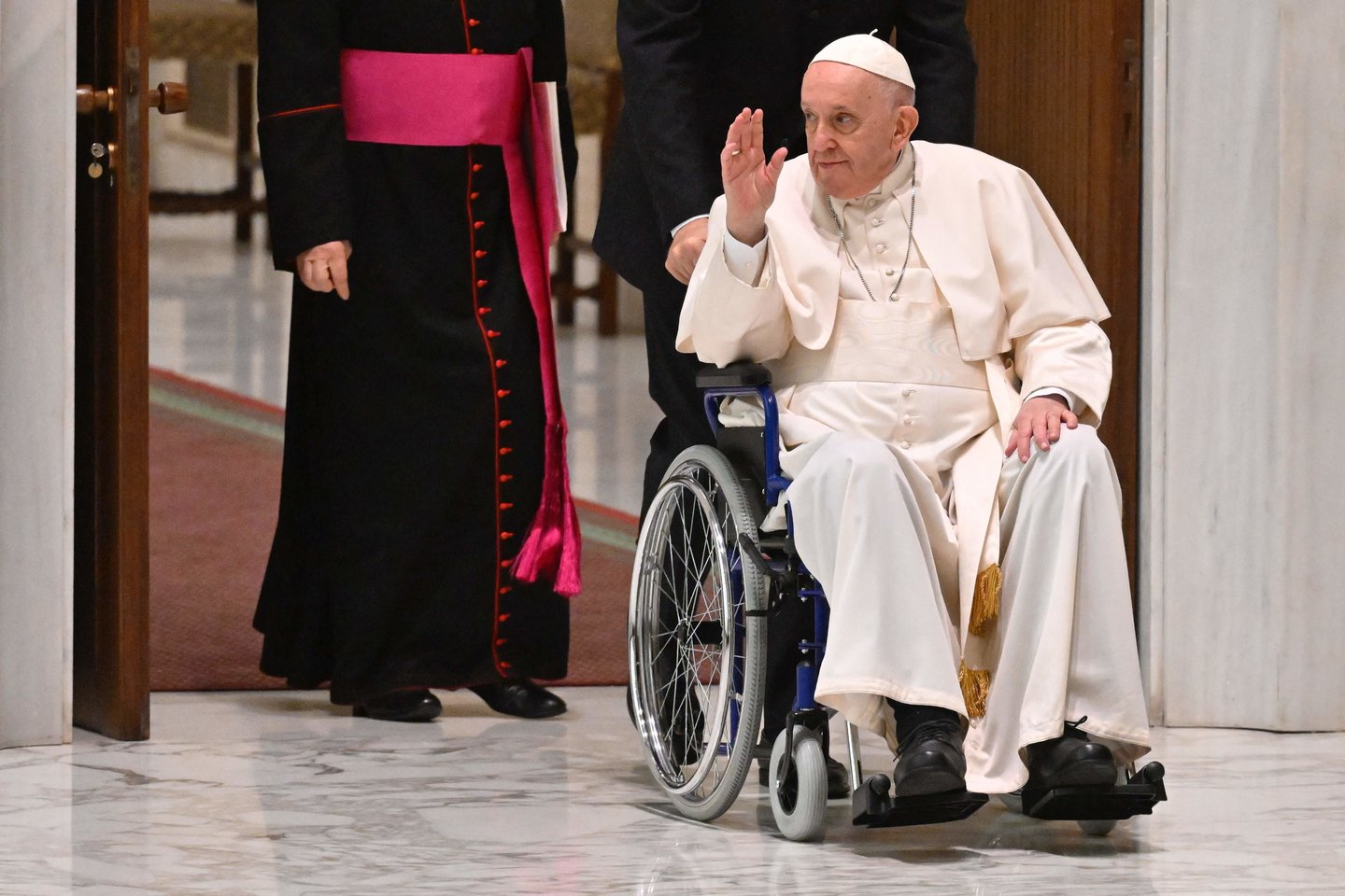 Pastarosiomis dienomis dažnai linksniuojamas Popiežius viešumoje pasirodė sėdėdamas neįgaliojo vežimėlyje.<br> AFP/Scanpix nuotr.