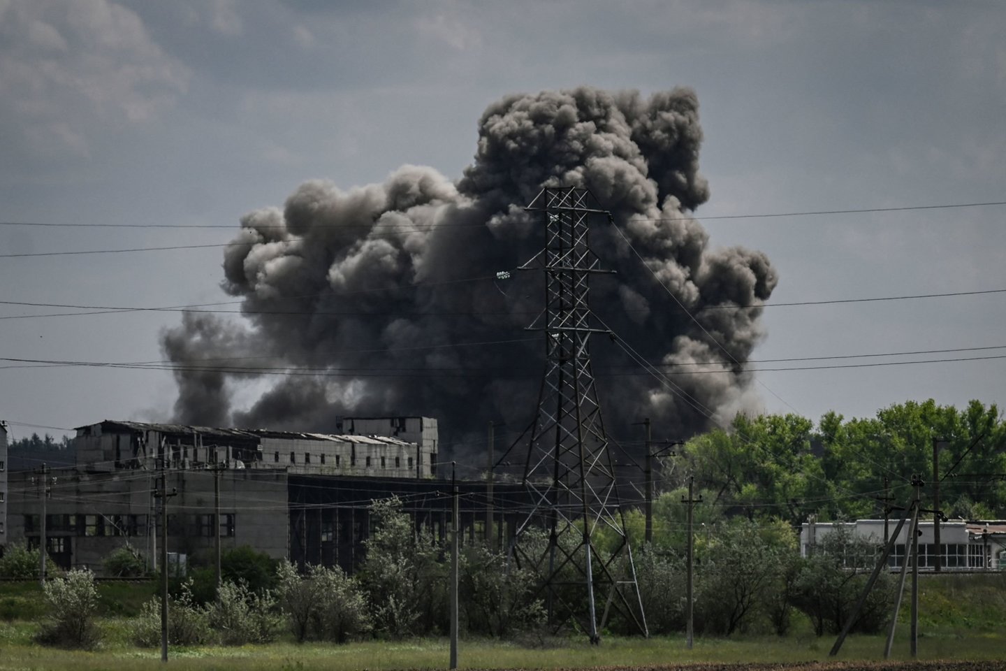  Dūmai ir dulkės kyla po smūgio į gamyklą Soledaro mieste rytiniame Ukrainos Donbaso regione 2022 m. gegužės 24 d., 90-ąją Rusijos invazijos į Ukrainą dieną.<br> AFP / Scanpix nuotr.