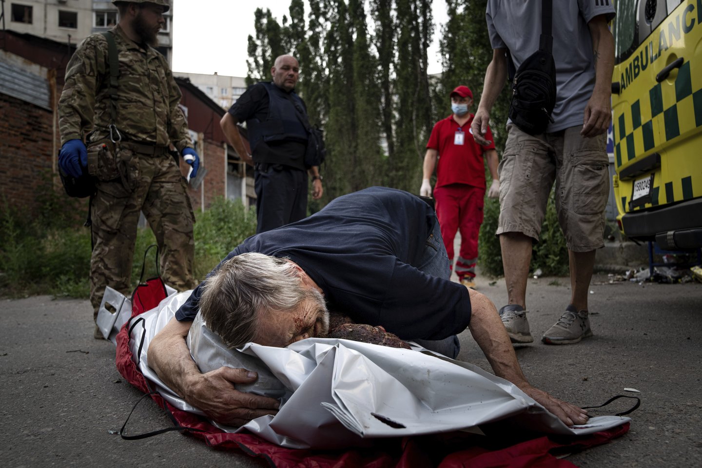  Viktoras Kolesnikas verkia prie savo žmonos Natalijos Kolesnikovos, kuri žuvo per Rusijos bombardavimą gyvenamajame kvartale Charkove, kūno. 2022 m. liepos 7 d.<br> AP / Scanpix nuotr.
