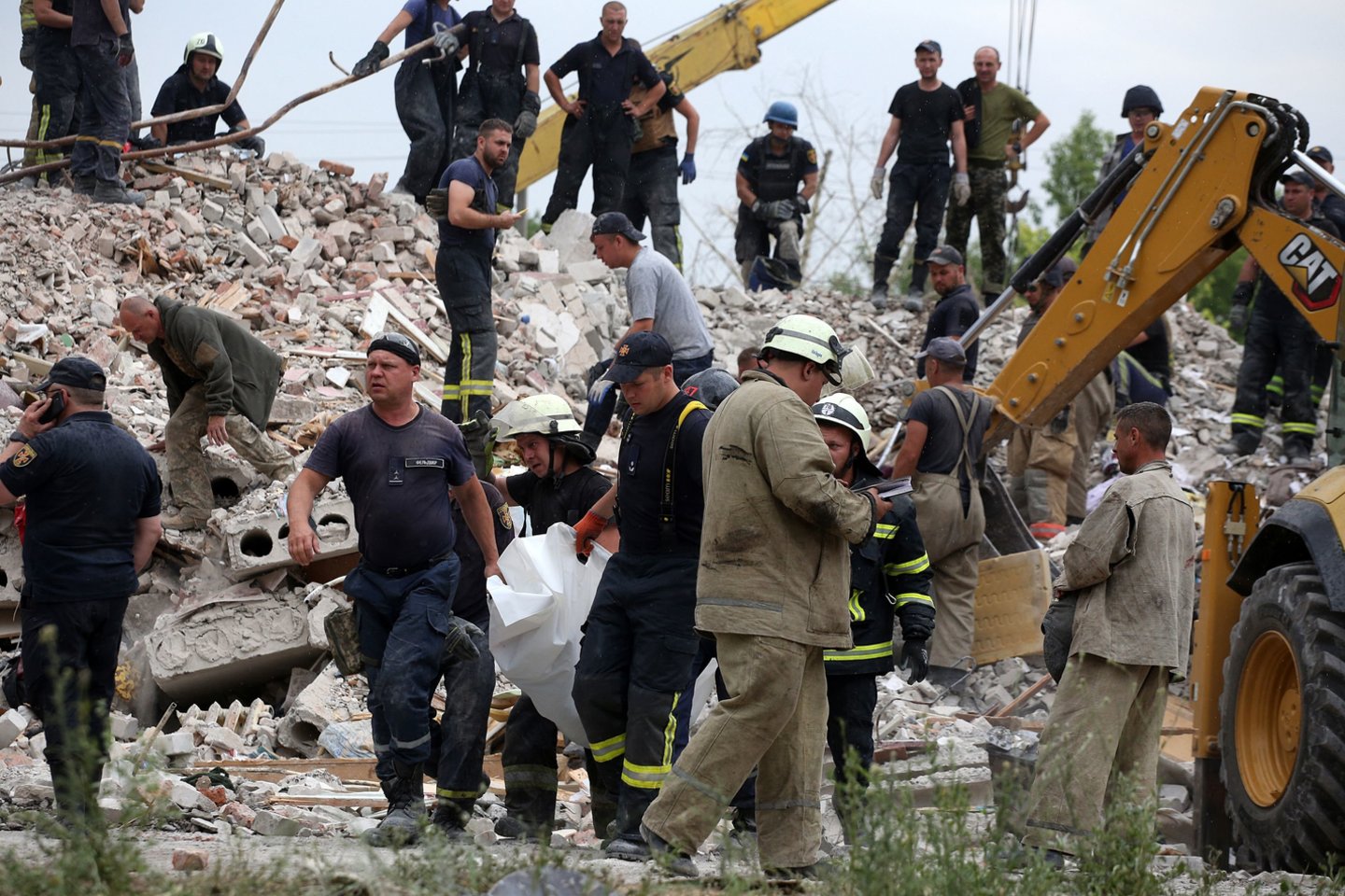  Gelbėtojai neša vyro kūną, po apšaudymo rastą griuvėsiuose Chasiv Jare, Rytų Ukrainoje, 2022 m. liepos 10 d. <br> AFP / Scanpix nuotr.