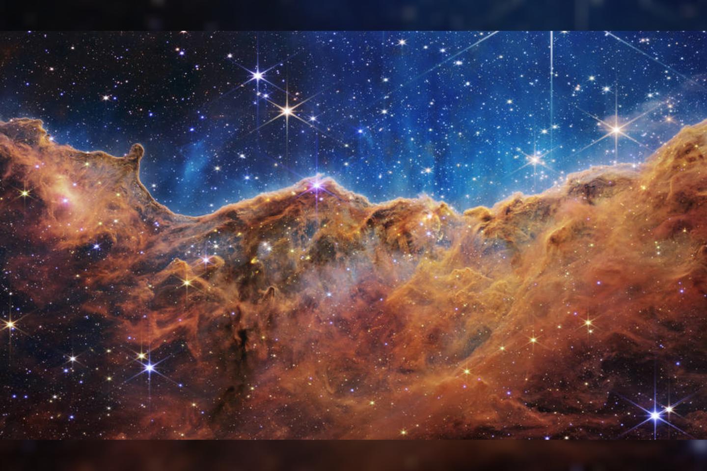  Šis „kalnų“ ir „slėnių“ vaizdas, nusėtas spindinčiomis žvaigždėmis, iš tikrųjų yra netoliese esančios jaunos žvaigždes formuojančios srities, vadinamos NGC 3324, esančios Laivo kilio ūke, pakraštys.<br> NASA / JWST nuotr.