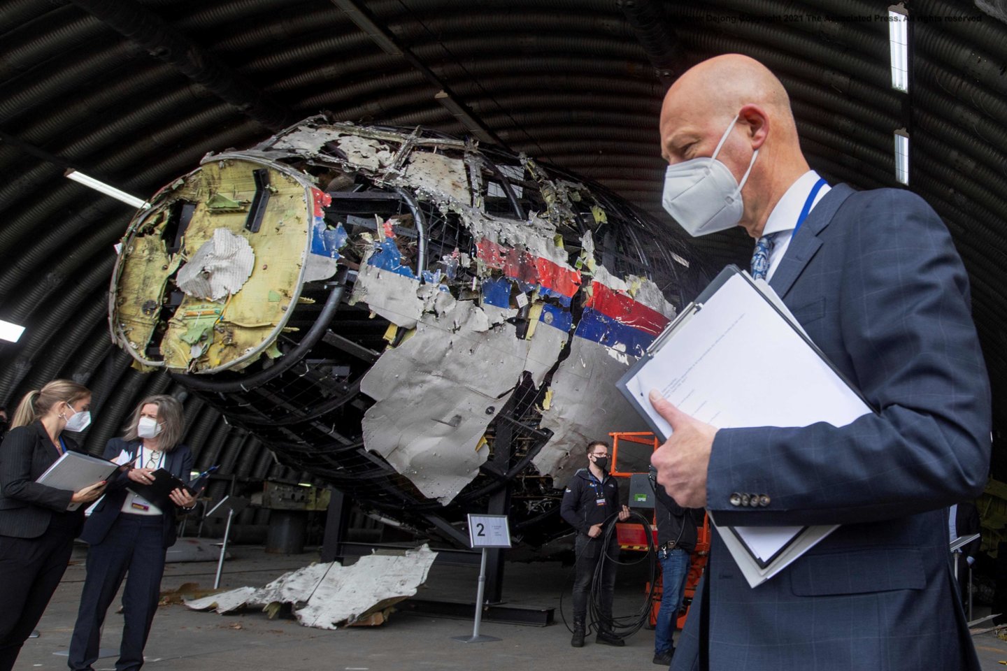  Šioje 2021 m. gegužės 26 d. darytoje nuotraukoje pirmininkaujantis teisėjas Hendrikas Steenhuisas ir kiti proceso teisėjai ir advokatai apžiūri rekonstruotas oro bendrovės "Malaysia Airlines" reiso MH17 lėktuvo nuolaužas Gilzės-Rijeno karinėje aviacijos bazėje.<br> AFP / Scanpix nuotr.