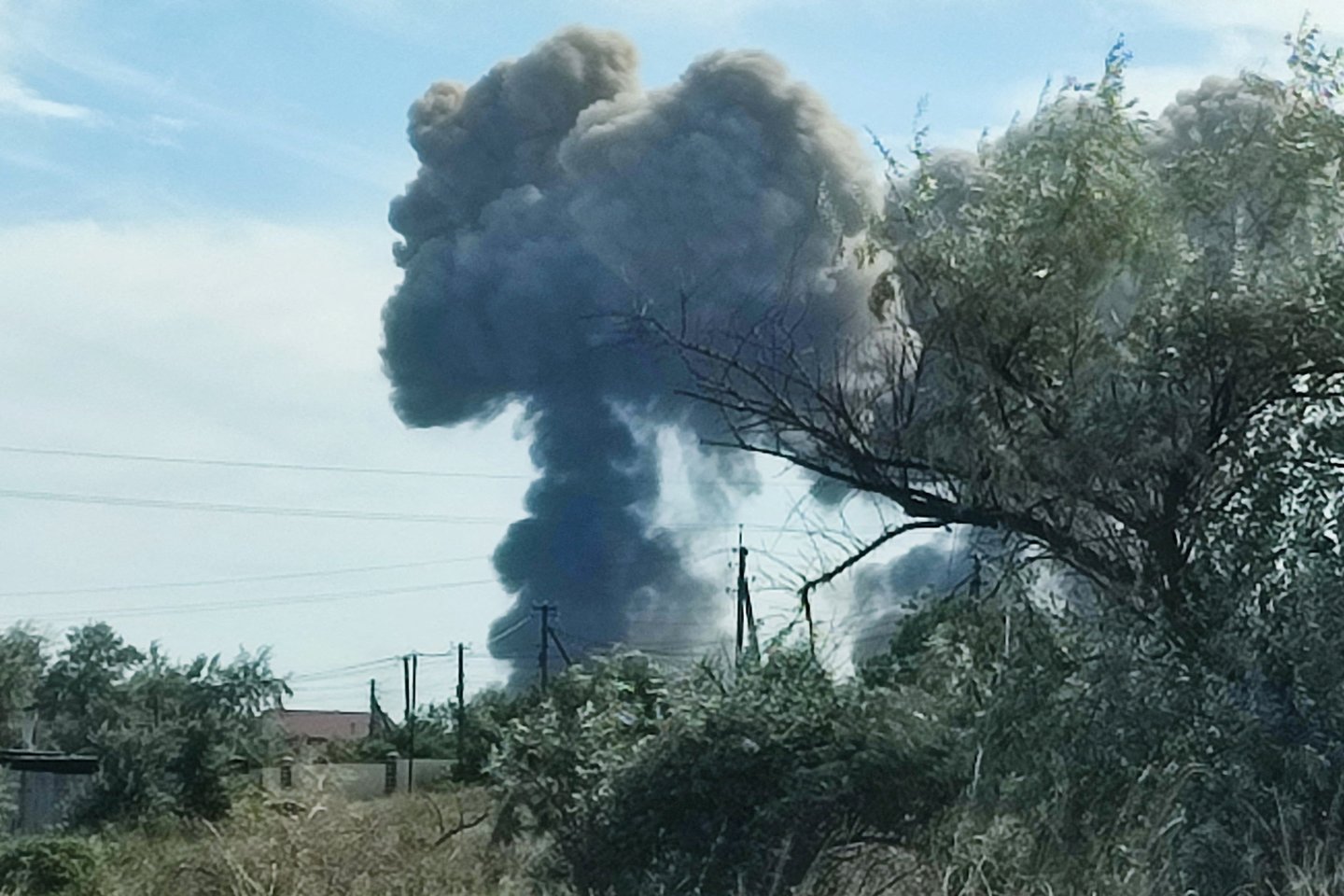 Karas Ukrainoje. Dūmai kyla po sprogimų, nugriaudėjusių iš Rusijos karinės oro bazės netoli Novofedorivkos, Kryme.<br>Reuters/Scanpix nuotr.