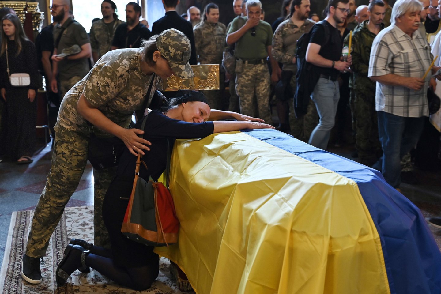 Ukrainos kariškio Romano Barvinoko motina Nadija gedi prie sūnaus karsto per laidotuvių pamaldas Kijevo katedroje 2022 m. rugpjūčio 28 d.<br> AFP / Scanpix nuotr.