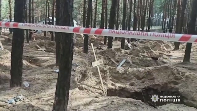 Teismo medicinos ekspertai ekshumuoja kūnus iš masinio laidojimo vietos Ukrainoje 