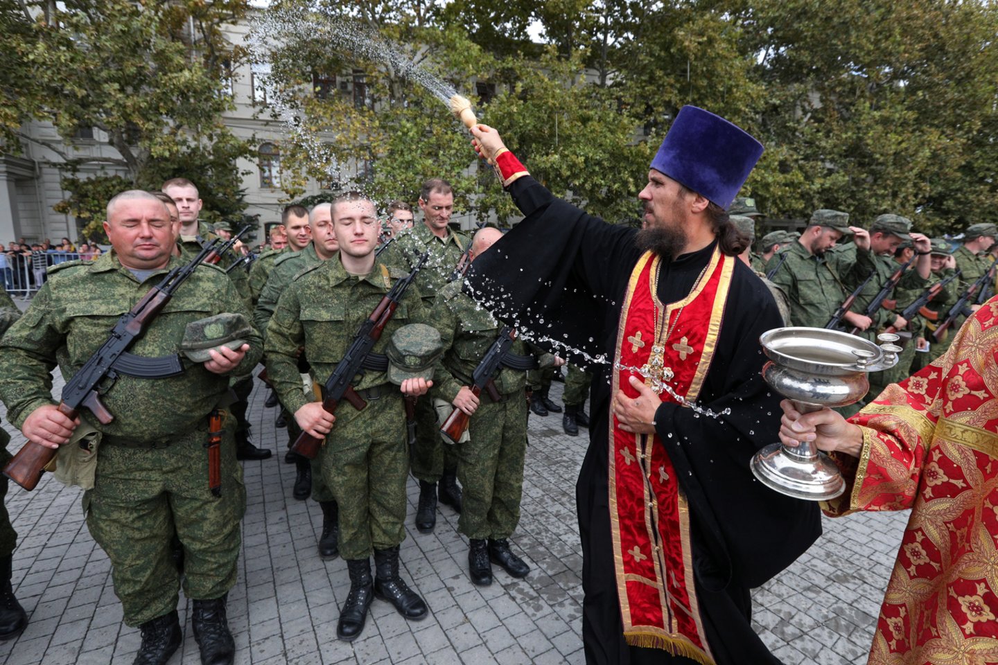 Stačiatikių šventikas laiko pamaldas rezervistams, pašauktiems į dalinę mobilizaciją, per jų išvykimo iš karinės bazės Sevastopolyje, Kryme. 2022 m. rugsėjo 27 d.<br> Reuters / Scanpix nuotr.