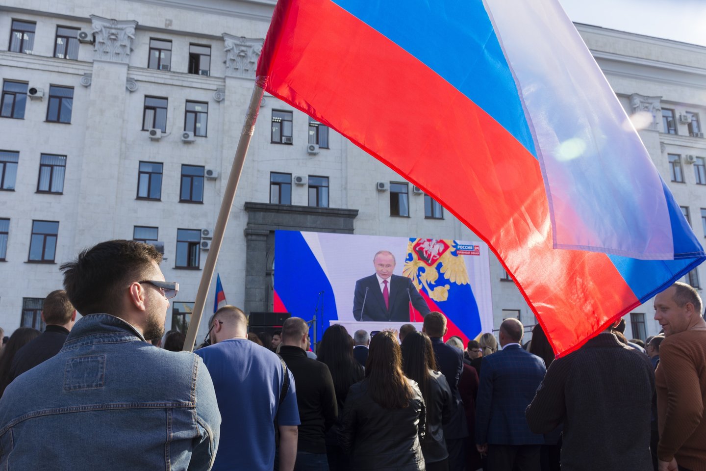 Karas Ukrainoje. Žmonės su Rusijos vėliavomis stebi Rusijos prezidento Vladimiro Putino kalbą.