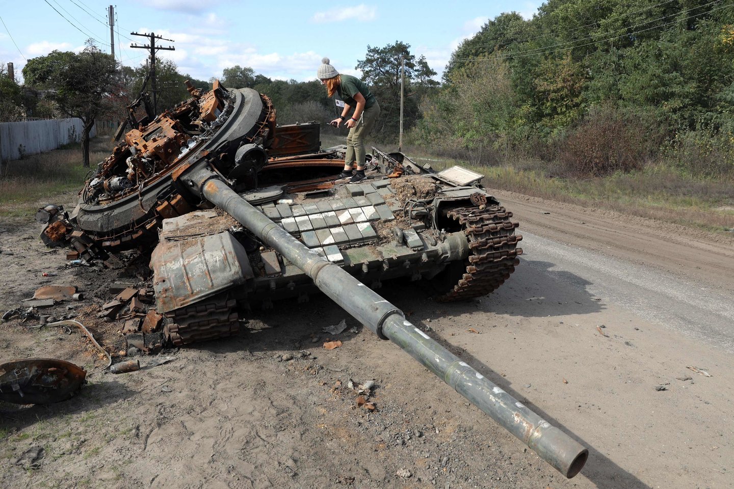 Mergina apžiūrinėja sunaikintą rusų tanką netoli Oskolio kaimo Charkovo srityje, 2022 m. spalio 9 d.. <br> AFP / Scanpix nuotr.