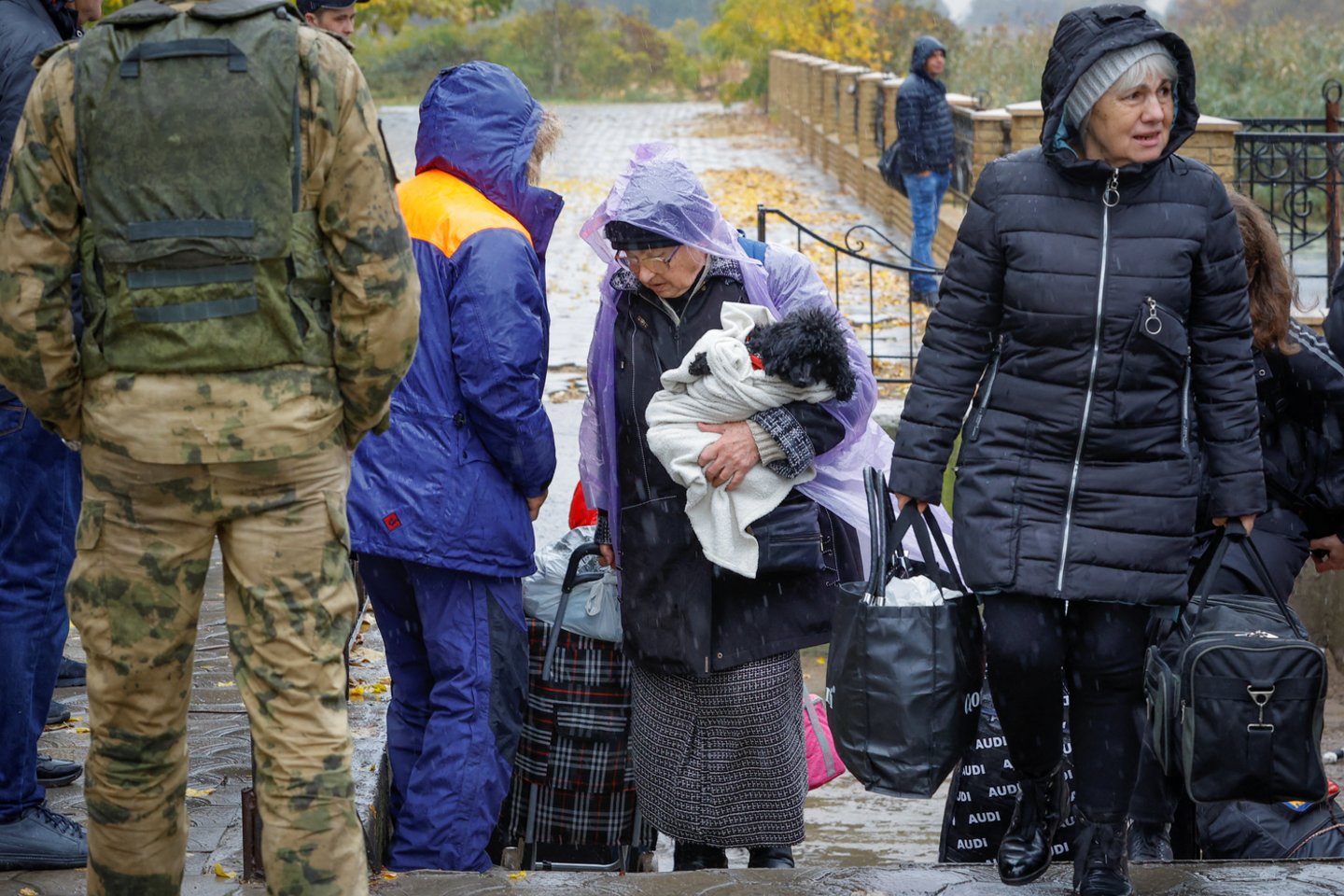 Iš Rusijos kontroliuojamo Chersono evakuoti civiliai gyventojai iš kelto eina į autobusą, važiuojantį į Krymą, Oleškio mieste, Chersono srityje, Rusijos kontroliuojamoje Ukrainoje, 2022 m. spalio 23 d.<br> Reuters / Scanpix nuotr.