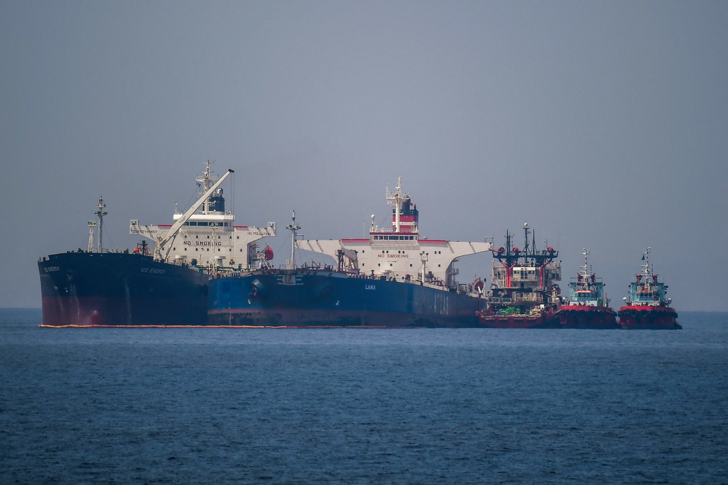 Tanklaivis perpila žalią naftą iš kito išplaukiojančio tanklaivio.<br> AFP/Scanpix asociatyvi nuotr.