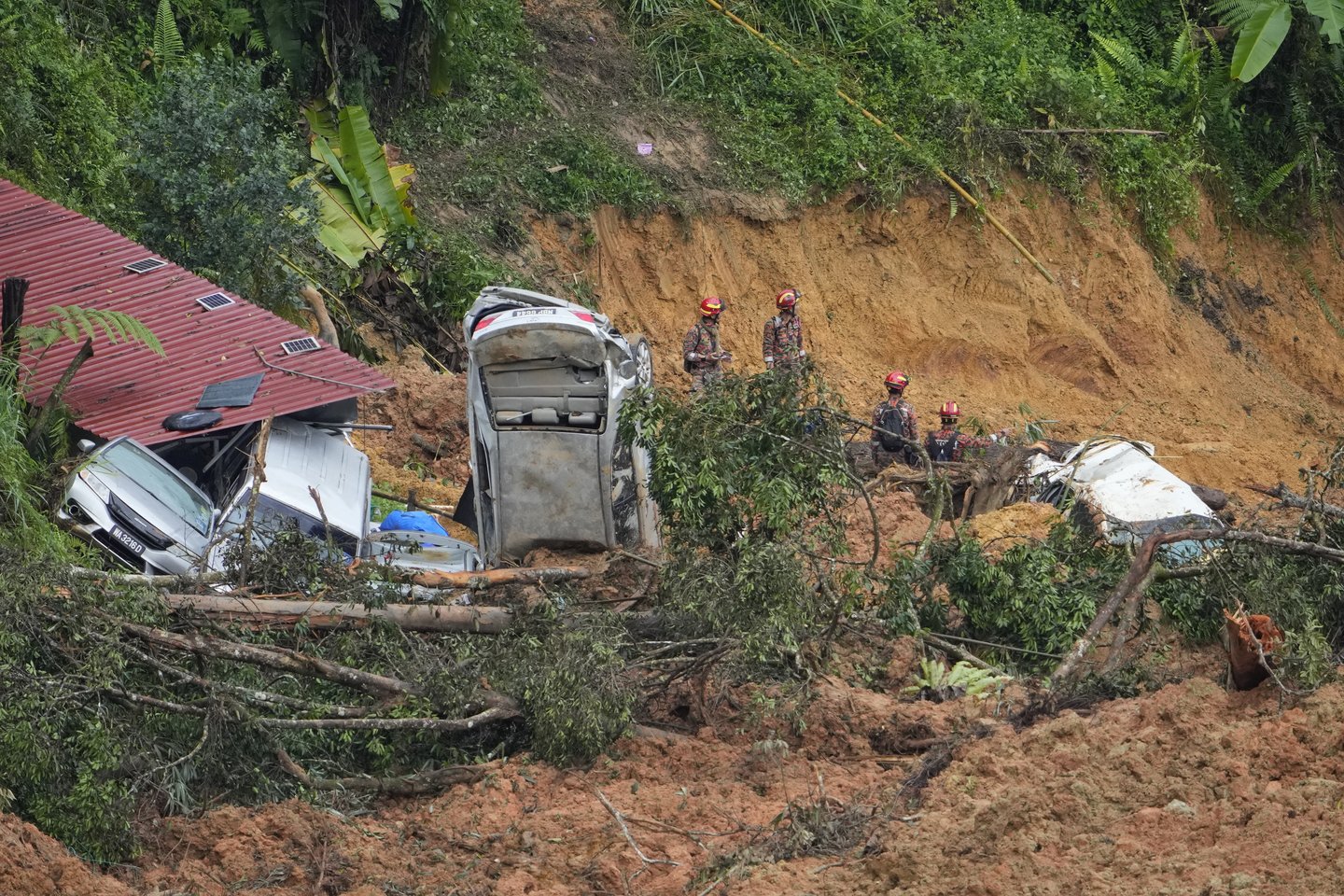 Nuošliaužai nuniokojus stovyklavietę Malaizijos ūkyje, aukų skaičius šeštadienį išaugo iki 23.<br>AP/Scanpix nuotr.