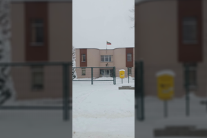 Praeivę suglumino kalėdinė dekoracija šalia seniūnijos pastato plevėsuojančios trispalvės 