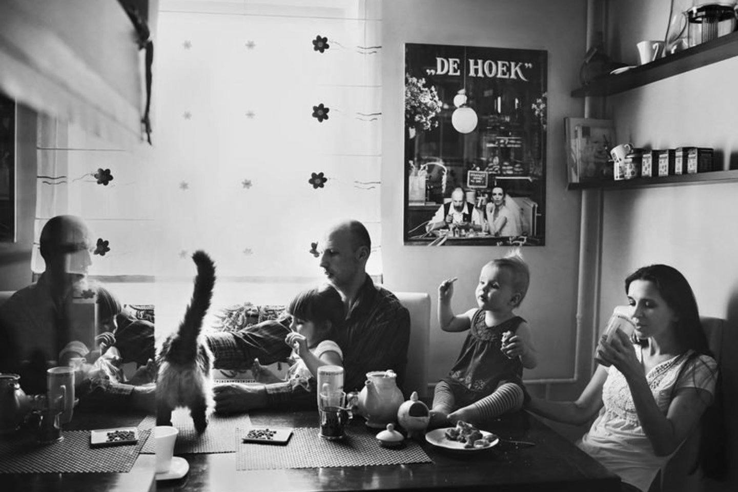 Klaipėdiečių Giedrės ir Andriaus šeimos pusryčiai namų virtuvėje. Gausi šeima, katinas, žuvų akvariumo stiklo atspindžiai, vaišės ant stalo, prieskoniai lentynėlėse. Ant sienos – vestuvinis pusryčiaujančių jaunavedžių portretas, kas rytą liudijantis augančios šeimos pusryčių ritualus.<br>Viktorijos Vaišvilaitės nuotr.