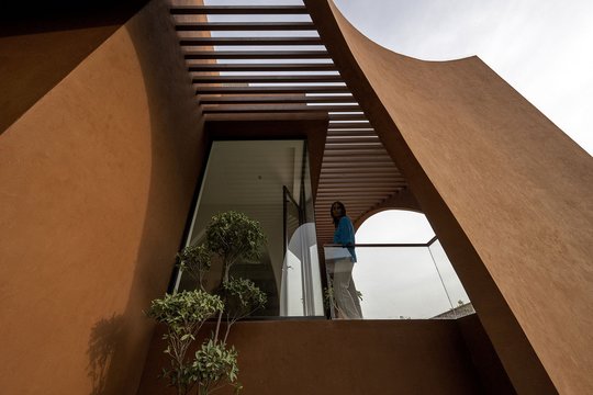 Arkos, gremėzdiškos sienos ir žemės spalvos tinkas – tai erdvaus, 920 kv. m ploto, namo Bylvaroje, kurį suprojektavo Mumbajuje veikianti architektų studija „Sanjay Puri Architects“, išskirtinumai.<br>Dinesh Mehta / archdaily.com nuotr.