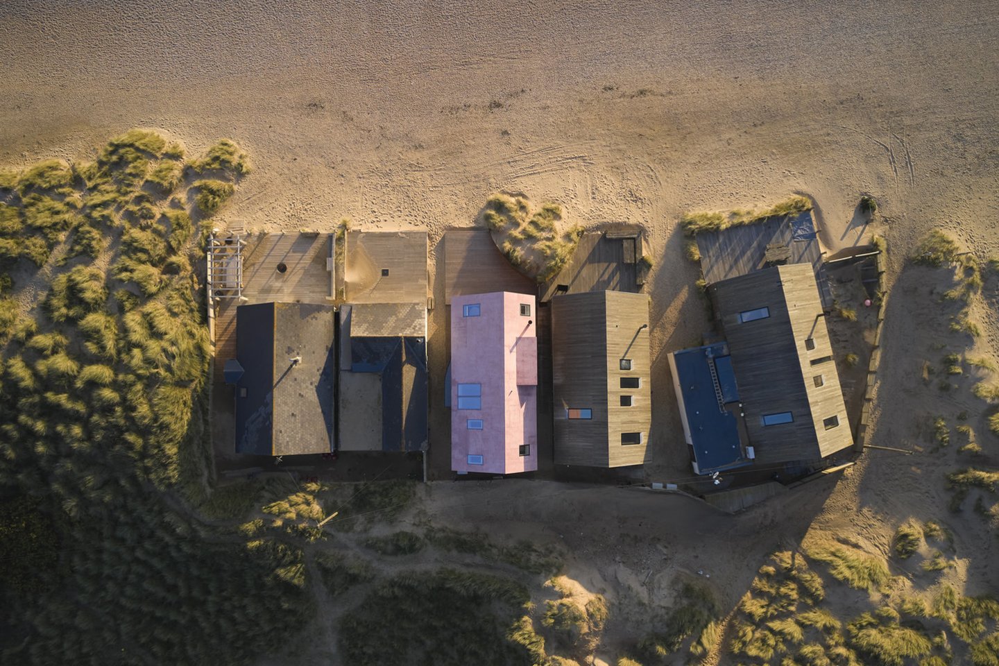 Nors šis ryškiai rožinis atostogų namas primena Viduržemio jūros regiono namus, jis stovi Jungtinėje Karalystėje, atšiauriame Camber Sands paplūdimyje.<br>Richard Chiver / archdaily.com nuotr.