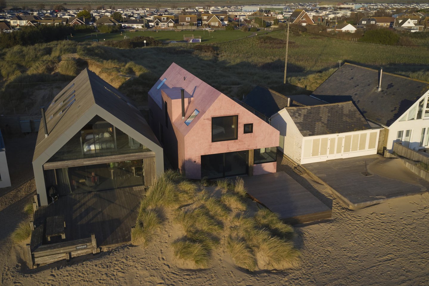 Nors šis ryškiai rožinis atostogų namas primena Viduržemio jūros regiono namus, jis stovi Jungtinėje Karalystėje, atšiauriame Camber Sands paplūdimyje.<br>Richard Chiver / archdaily.com nuotr.