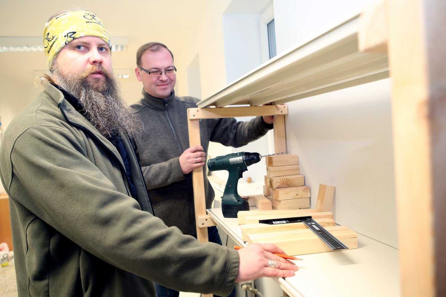 A.Šiuša ir H.Ramonas (kairėje) sumontavo lentynas, į jas moterys krovė daiktus. <br>M.Patašiaus nuotr.