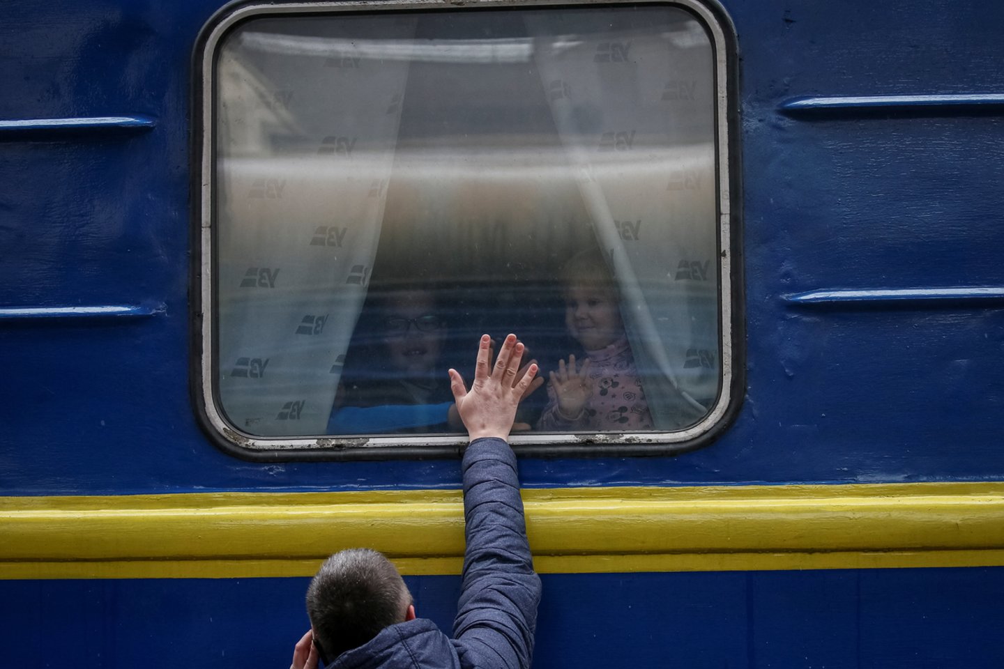  Children look out from an evacuation train from Kyiv to Lviv as they say goodbye to their father at Kyiv central train station in central Kyiv, Ukraine March 3, 2022.<br> Reuters / Scanpix