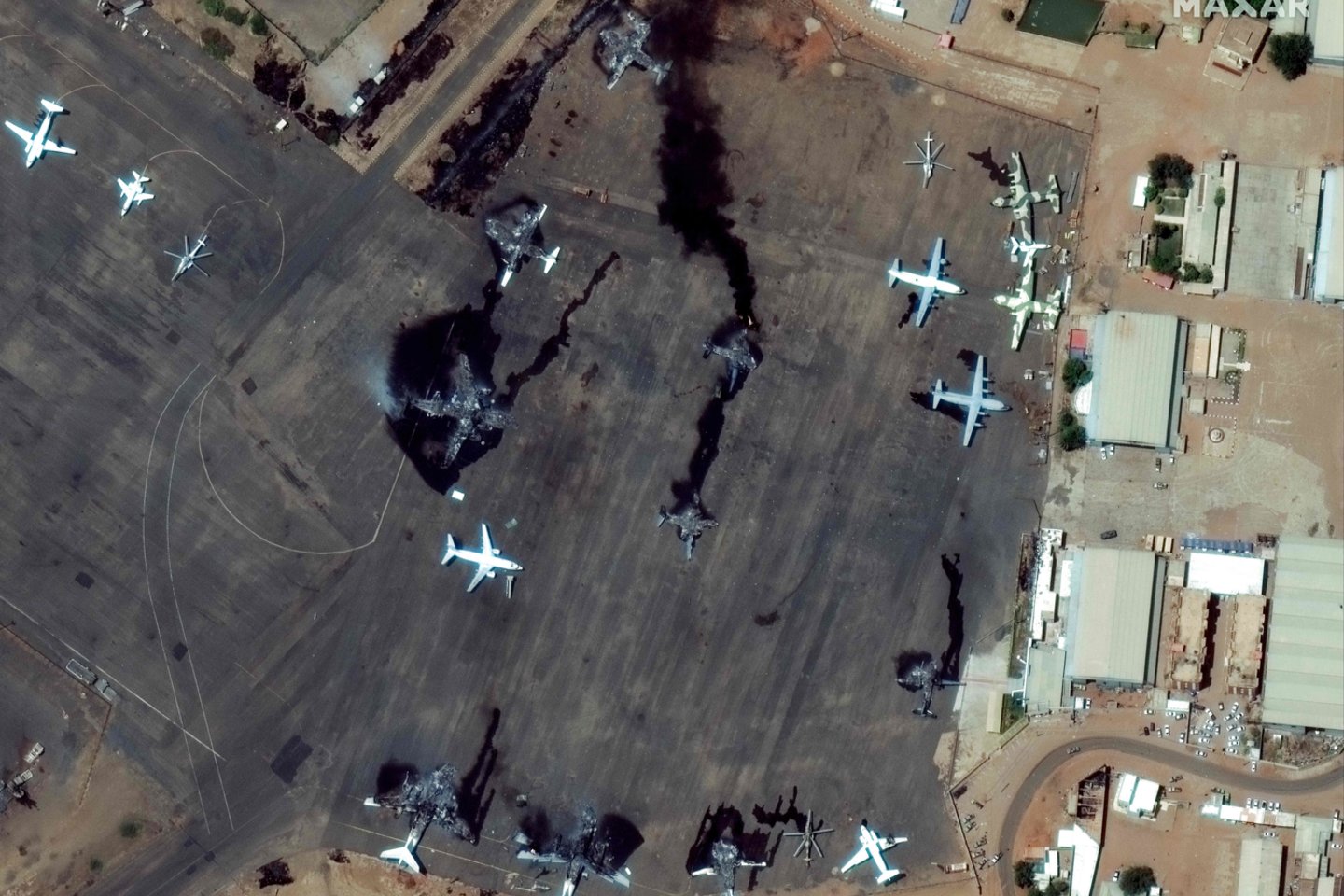 Palydovinėje nuotraukoje matyti Chartumo tarptautiniame oro uoste sunaikinti lėktuvai.<br>AFP/Scanpix nuotr.