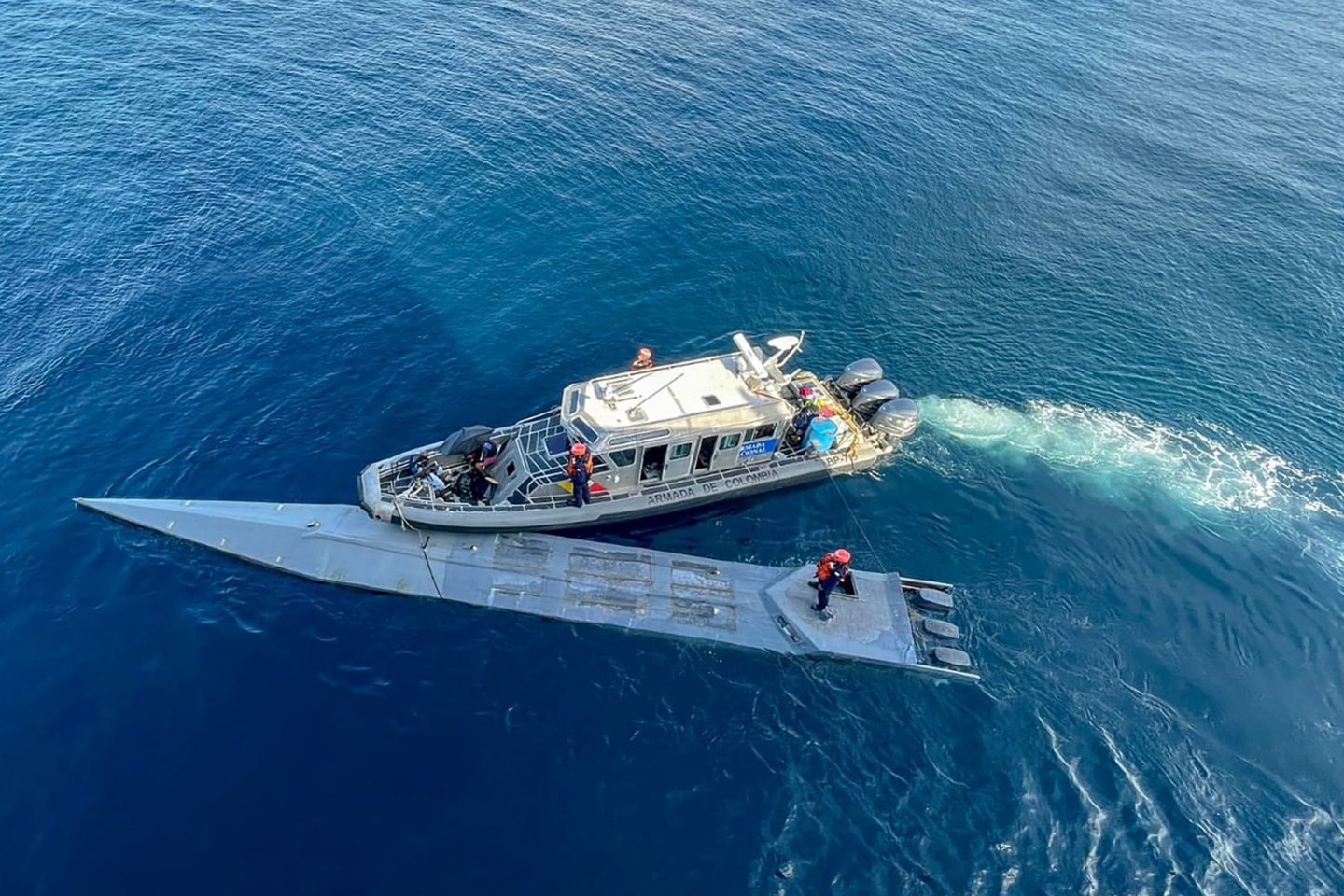 Šioje Kolumbijos nacionalinio karinio jūrų laivyno išplatintoje nuotraukoje matyti, kaip 2023 m. kovo 13 d. Kolumbijos Ramiojo vandenyno pakrantėje karinio jūrų laivyno nariai sulaiko pusiau povandeninį laivą, gabenusį kokaino hidrochloridą.<br>AFP/Scanpix nuotr.