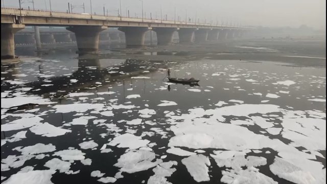 Vaizdai iš Indijos: šalį gaubiant smogui, vieną upių užklojo nuodingų putų kauburiai