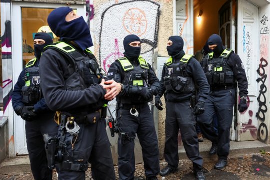 Vokietijos policijos pareigūnai stovi prie daugiabučio namo per reidą prieš palestiniečių islamistų grupuotę „Hamas“ remiančius asmenis Berlyne.