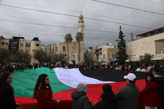 Palestiniečiai solidarizuojasi su Gazos Ruožo gyventojais Kalėdų išvakarių eisenoje, vykusioje Mangerio aikštėje, vedančioje į Jėzaus Kristaus gimimo bažnyčią, kuri tradiciškai laikoma Jėzaus Kristaus gimimo vieta, Vakarų kranto Betliejaus mieste, 2023 m. gruodžio 24 d.<br>EPA-ELTA nuotr.