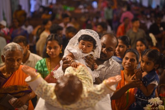 Vaikas liečia kūdikėlį Jėzų Kristų vaizduojančios statulos pėdas po maldų per Kalėdų šventąsias Mišias Santhome katedros bazilikoje, Čenajuje, Indijoje.<br>EPA-ELTA nuotr.