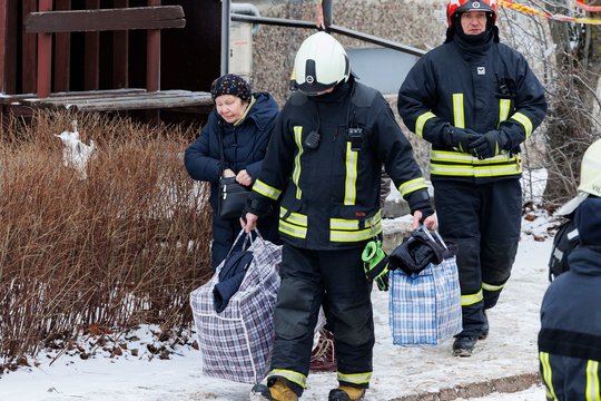  Po gaisro Viršuliškių daugiabutyje žmonės įleidžiami į smarkiai apgadintą namą pasiimti būtiniausių daiktų.<br> T.Bauro nuotr.