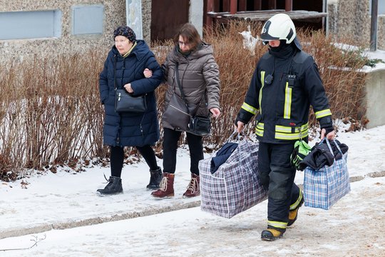  Po gaisro Viršuliškių daugiabutyje žmonės įleidžiami į smarkiai apgadintą namą pasiimti būtiniausių daiktų.<br> T.Bauro nuotr.