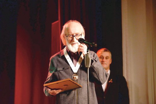 Kūrėjas A.Adomaitis scenoje nusiėmė jam įteiktas garbės piliečio regalijas.