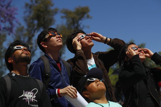  Žmonės Meksikoje ir JAV stebi saulės užtemimą.<br> EPA-ELTA nuotr.