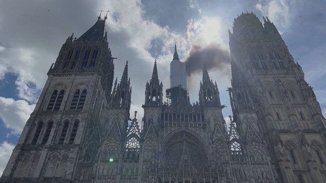 Liepsnojančios katedros Prancūzijoje vaizdai: žmonės, apimti siaubo ir iš bokšto kylantis tamsus dūmų debesis