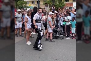 Technologijų stebuklai ir jaudinančios akimirkos: olimpinį deglą Paryžiuje nešė vaikščioti negalintis žmogus