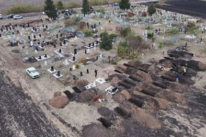 Rusai atakuoja ir mirusiuosius: smogė į kapines Ukrainoje, nužudyta sūnaus kapą tvarkiusi moteris