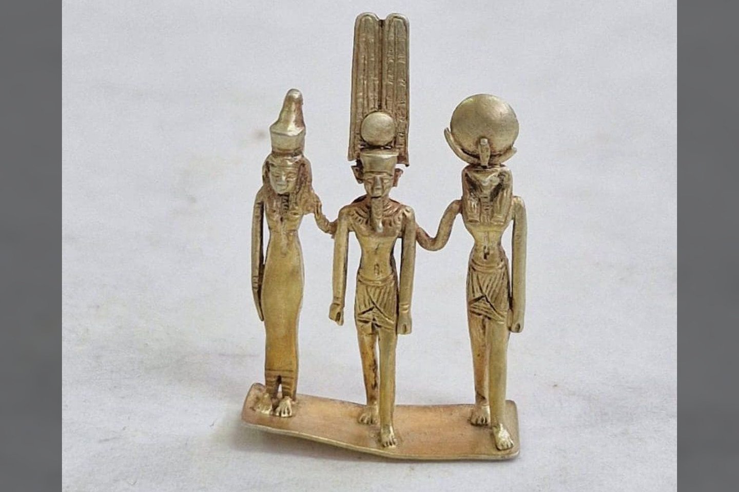 Vienas ryškiausių radinių – auksinė statulėlė, kurioje pavaizduotos viena šalia kitos stovinčios dievybės Mut, Amonas ir Chonsas.<br> Egipto turizmo ir senienų ministerijos nuotr.