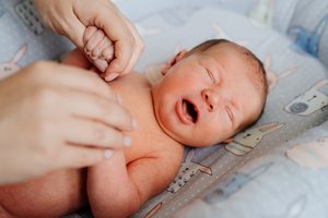 Prajuokino pasaulį: nufilmuotas naujagimis, rankoje laikantis savo mamos kontraceptinę spiralę