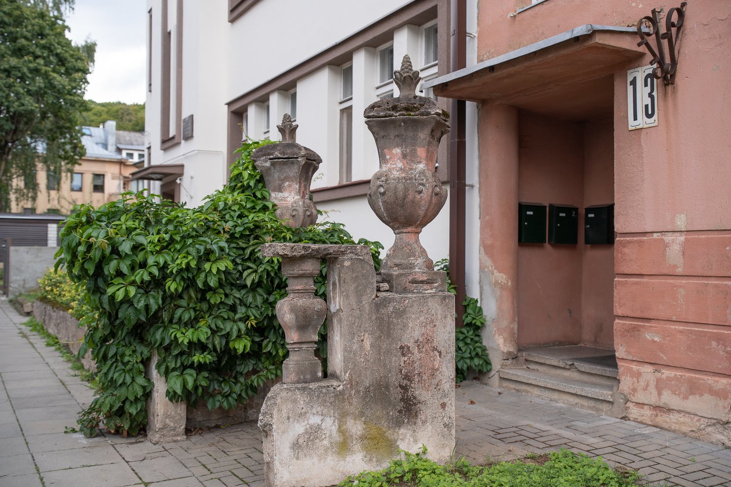 Krėvos gatvėje prie 13-ojo tarpukariu pastatyto daugiabučio stovi senos mūrinės tvoros likučiai, kurią puošia įspūdingos vazos.<br>R.Vilkelio nuotr.
