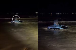 Kraują stingdantys vaizdai: potvynis įkalino vyrą ir mažylį ant automobilio stogo