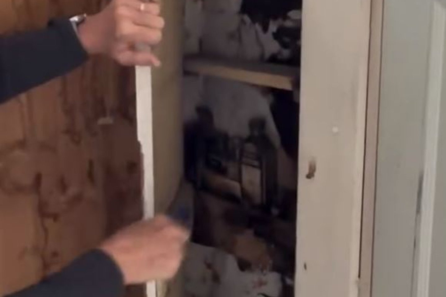 Moteris namuose atrado slaptas duris.<br>„Facebook“ vaizdo įrašo stop kadras.