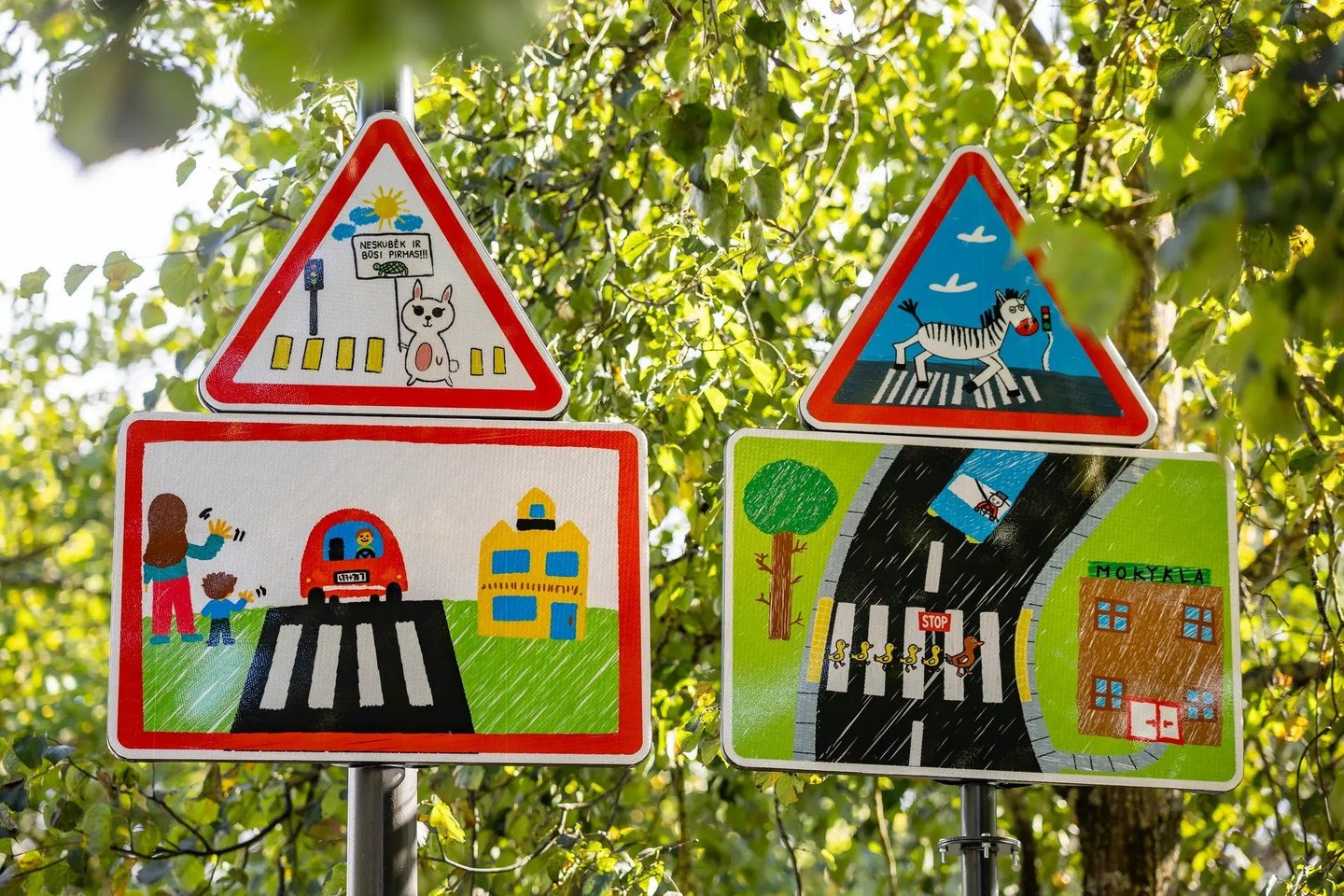 Nauji mokslo metai Pašilaičiuose prasidėjo labai spalvingai – Medeinos gatvėje buvo įrengti pradinių klasių moksleivių piešinių įkvėpti kelio ženklai.<br> Vilnius.lt nuotr.