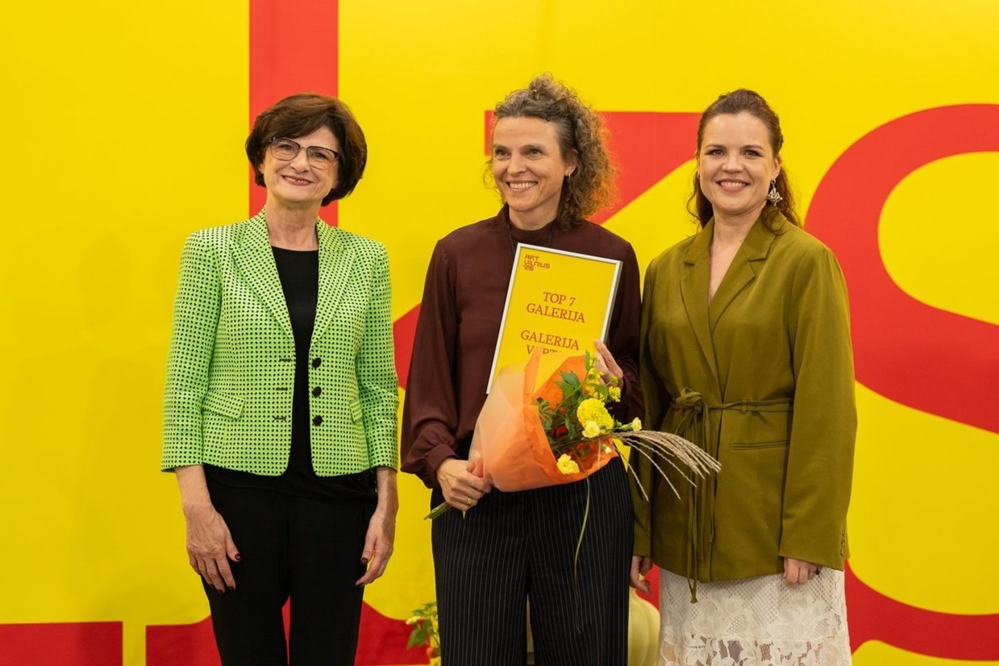 Laurai Rutkutei (centre) ArtVilnius'26 rengėjos įteikė diplomą, liudijantį, kad komisija išrinko „Vartus“ viena geriausių mugės galerija.<br>ArtVilnius'26/A.Vasilenko nuotr.
